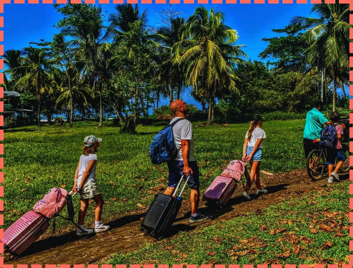 Familia con maletas llegando a Tortuguero, Costa Rica, bajo un cielo despejado y soleado, con un fondo de palmeras altas que se balancean suavemente con la brisa.