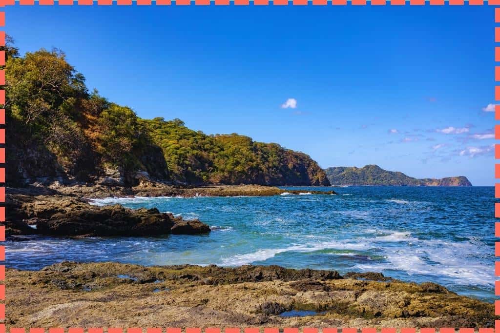 Vista escénica de Playa Ocotal en Costa Rica, destacando sus características rocas y la tranquila atmósfera costera.