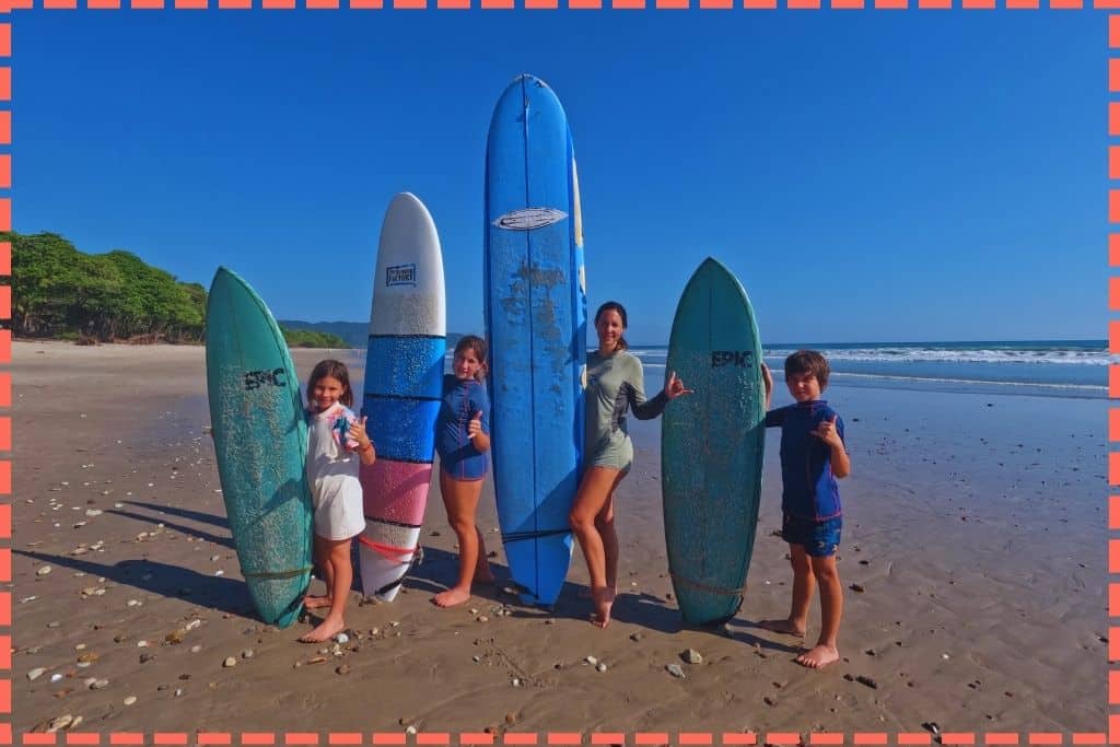 Tere Watson y tres hijos posando con sus tablas de surf en la encantadora Playa Santa Teresa.