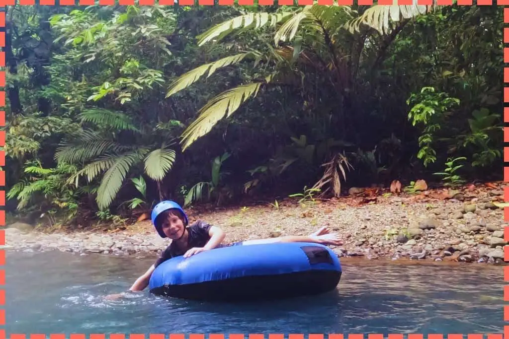 Niño disfrutando del tubing en el Río Celeste, Costa Rica.