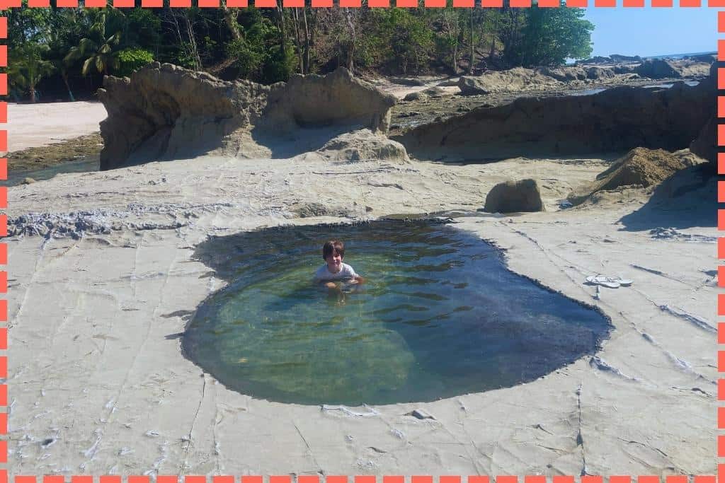 Ian (niño) disfrutando en una hoya formada entre las piedras en la serena Playa Mar Azul.