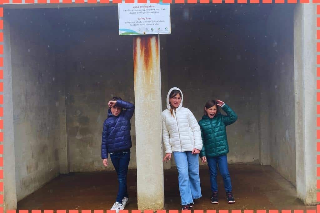 3 hijos de Tere Watson a cubierto en una caseta para cubrirse del agua de la lluvia que parece que nivea en Costa Rica.