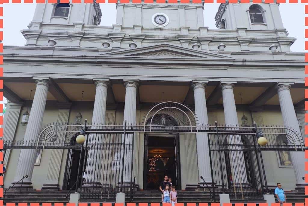 La familia Watson posa en las escaleras de entrada de la Catedral Metropolitana de San José, Costa Rica. La foto muestra el majestuoso exterior de la catedral, un punto de referencia histórico y arquitectónico en el centro de la ciudad, destacando su importancia en las actividades culturales y turísticas de San José.