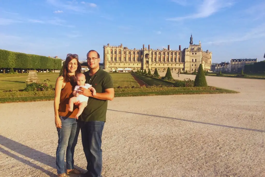 Tere Watson y su marido con su bebé en brazos frente al majestuoso Palacio de Versalles en Francia. La foto captura un momento familiar encantador en uno de los sitios más emblemáticos de Europa, resaltando la belleza arquitectónica del palacio y la alegría de compartir viajes en familia.