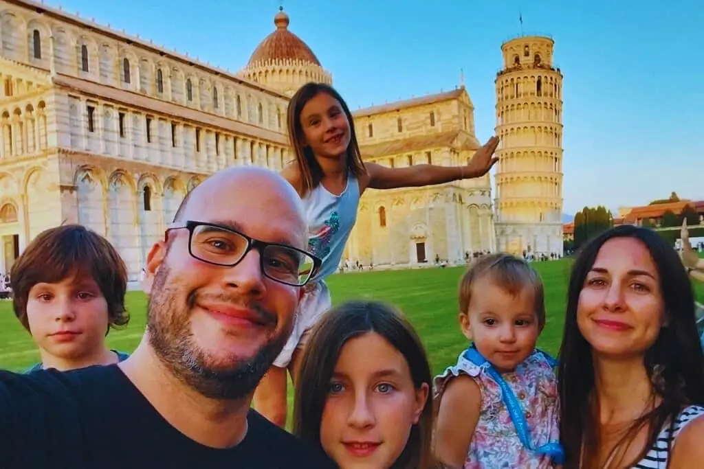 La Familia Watson al completo frente a la torre de Pisa. Vicky hace que se apoya en ella y los demás sonríen en sus vacaciones en familia.
