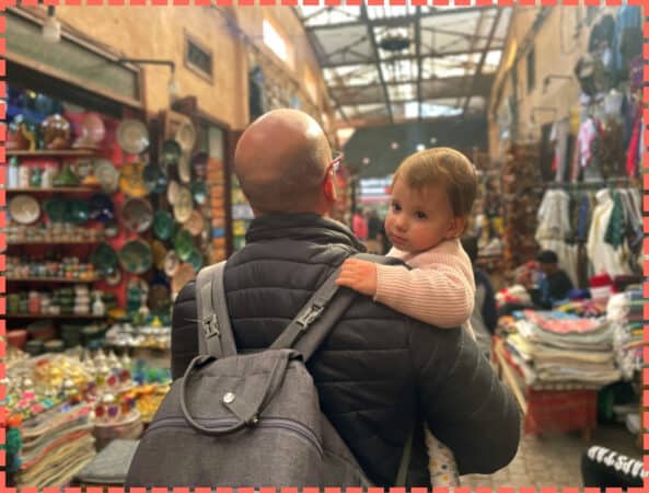 Papá con bebé en brazos por los zocos de Marrakech.