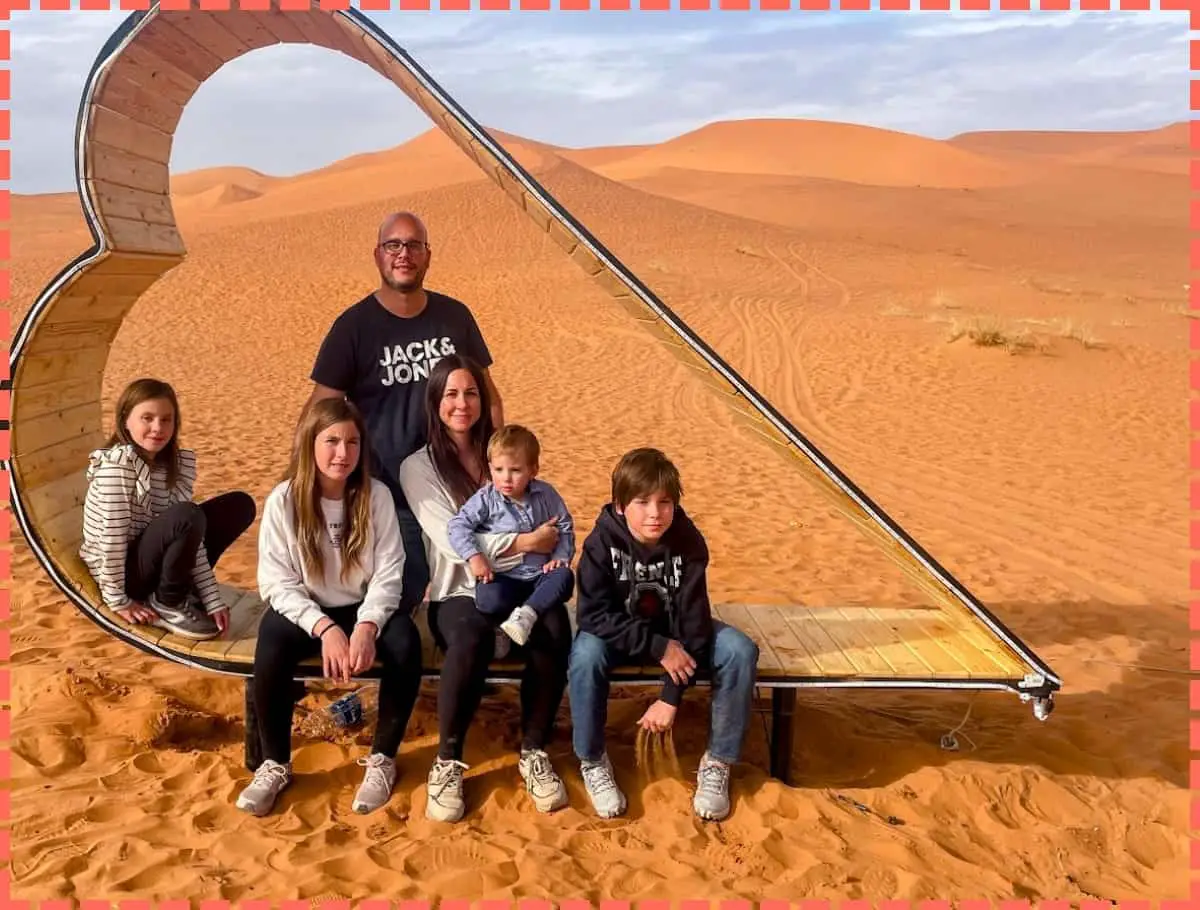 Familia Watson dentro de un carazón en el desierto de Merzouga en nuestro viaje a marruecos