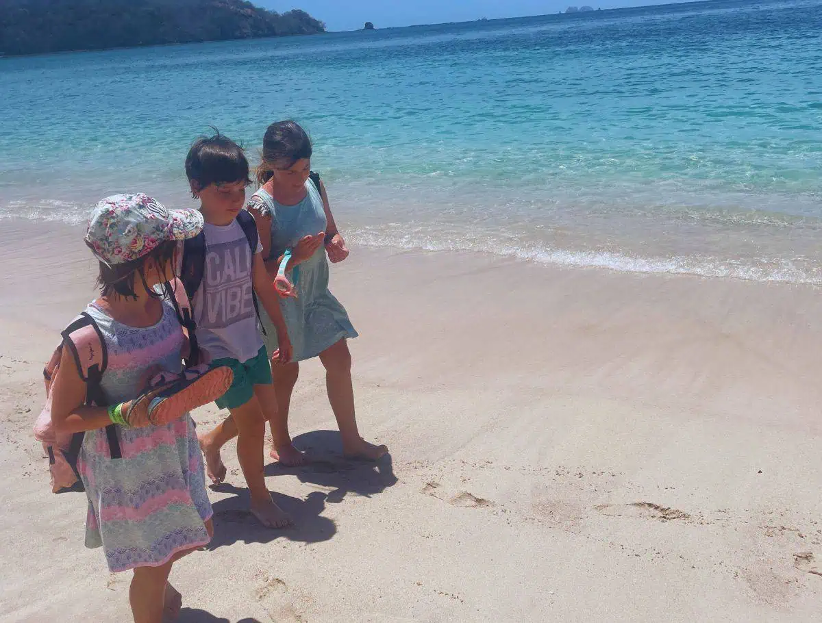 3 niños caminando por la costa de Playa Conchal Guanacaste