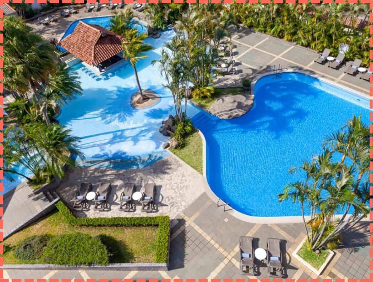 Foto aérea zona piscinas del hotel Wyndham San José Herradura.